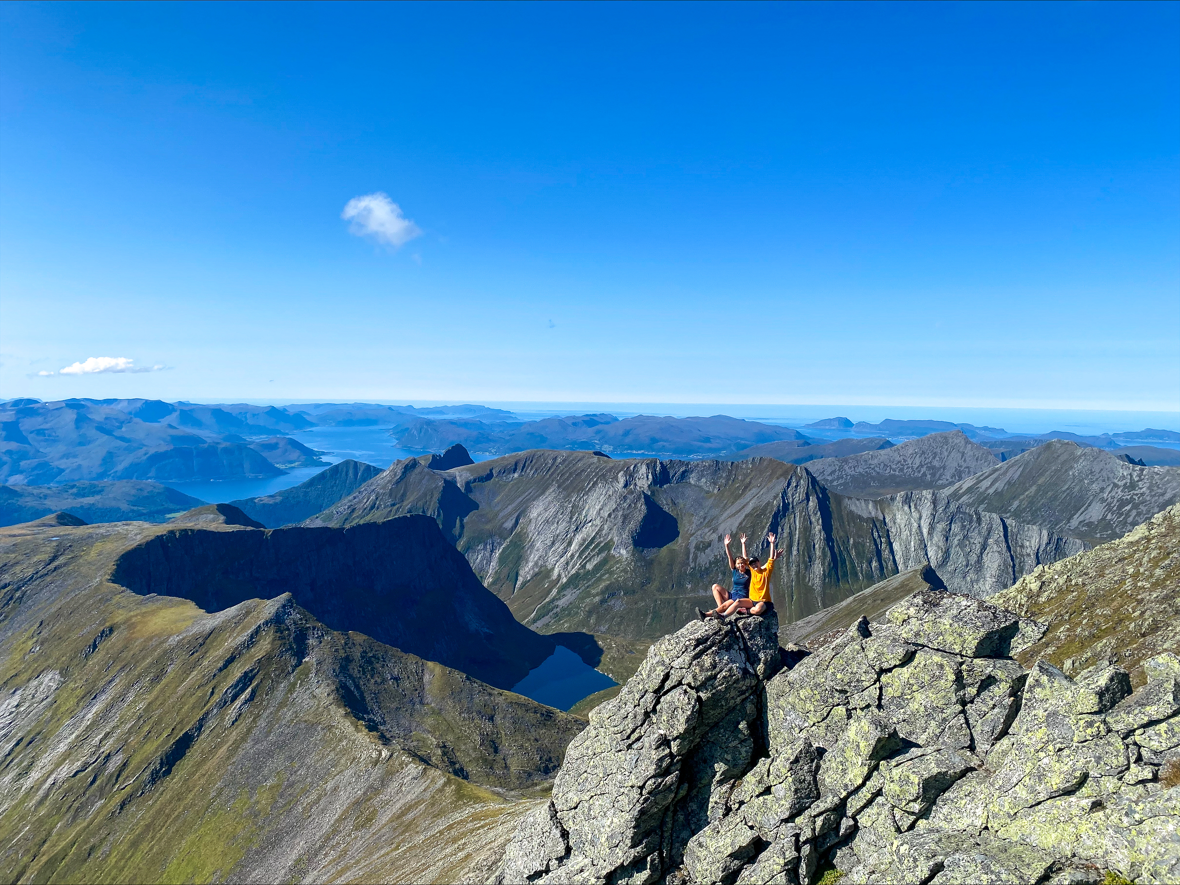 Utsiktsbilde fra fjelltopp med bl&aring; himmel.