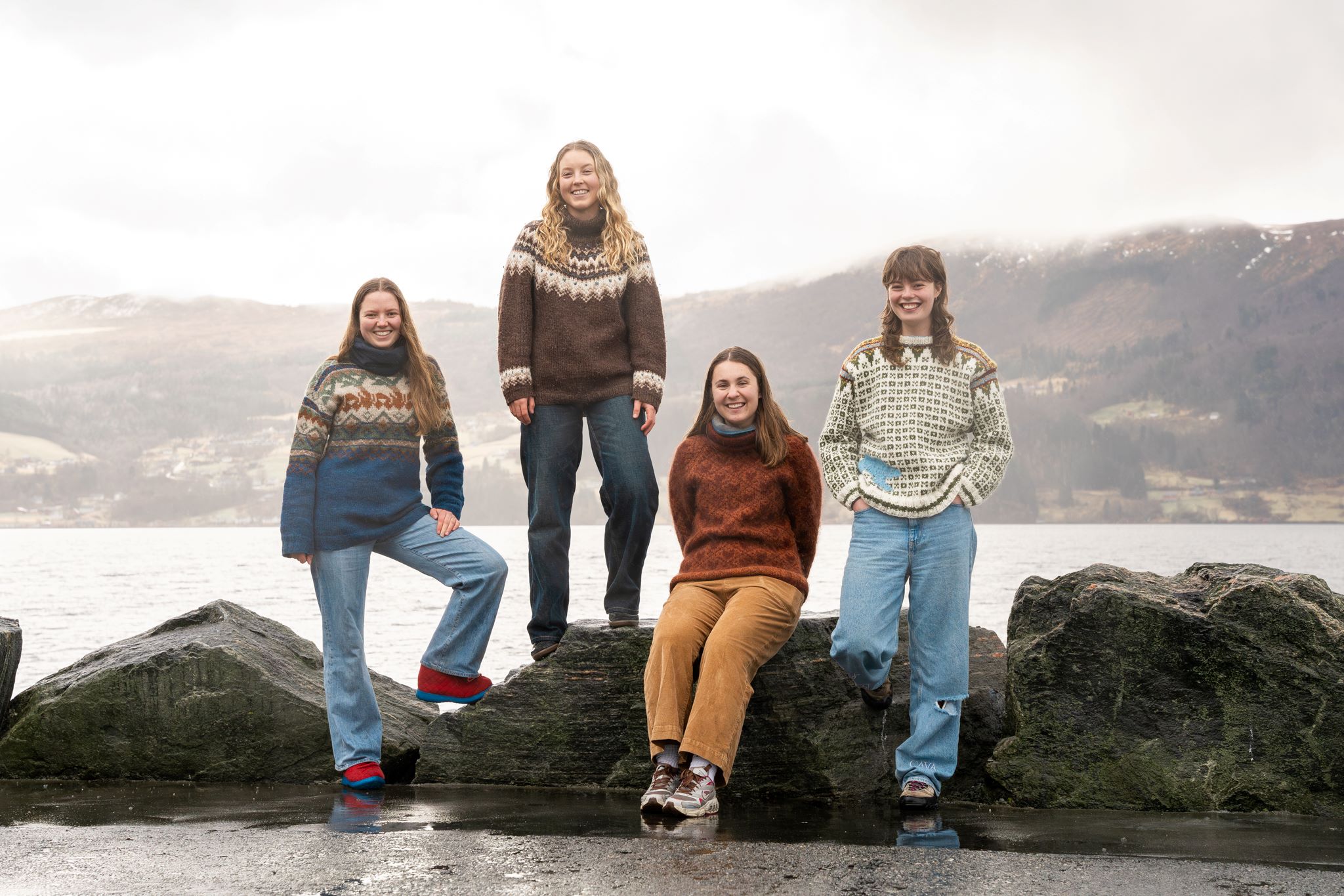 Fire smilande studentar oppstilt ved fjorden