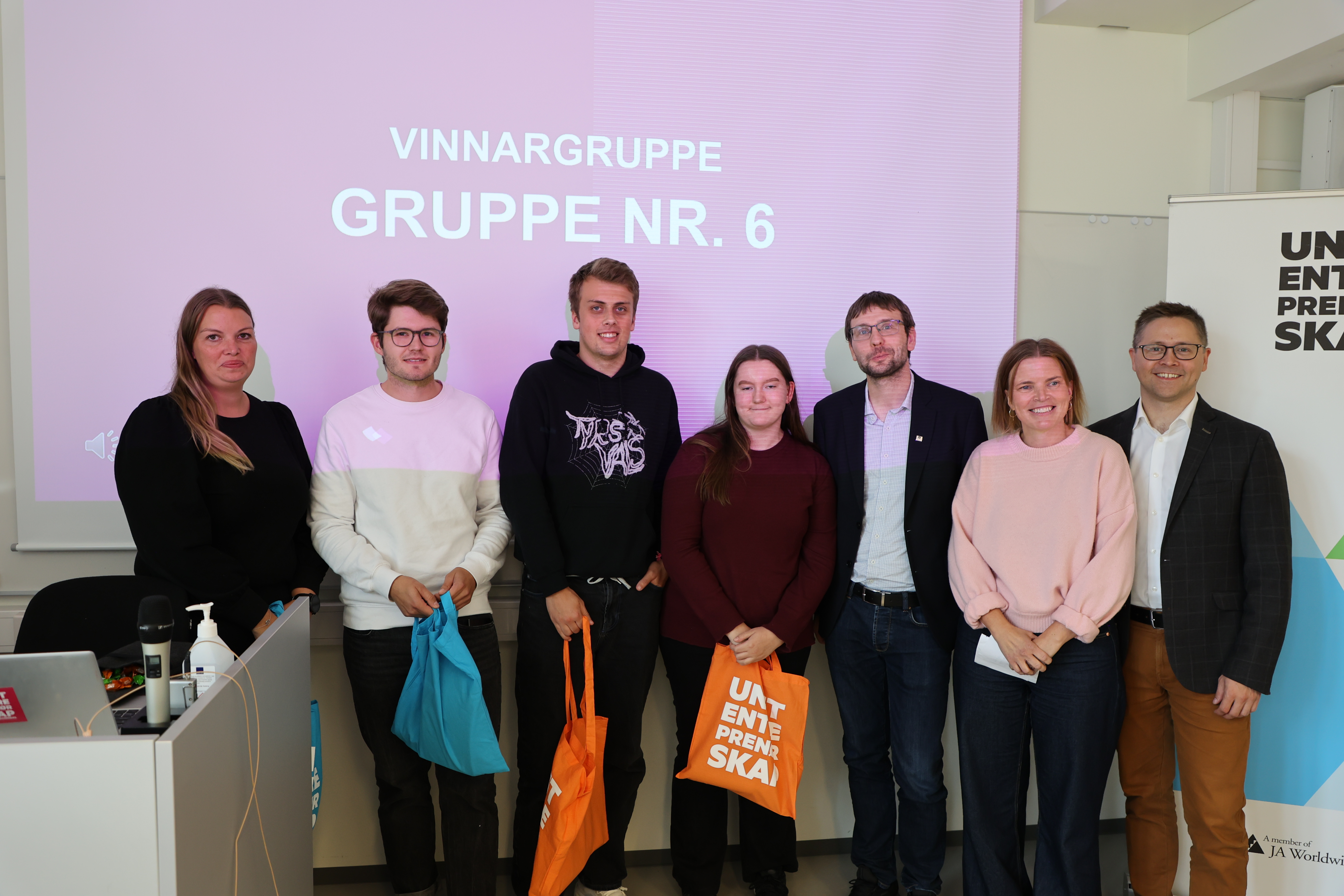 Vinnargruppa saman med juryen. Helga Gr&oslash;nnevik (f.v.), Magnus Helland, Kevin Pettersen, Linn Amalie Iversen, Eirik S&oslash;vik, Janne Heggvoll og Ruben Grongstad Kvalsvik.