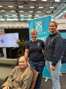 Tre personer som står på stand