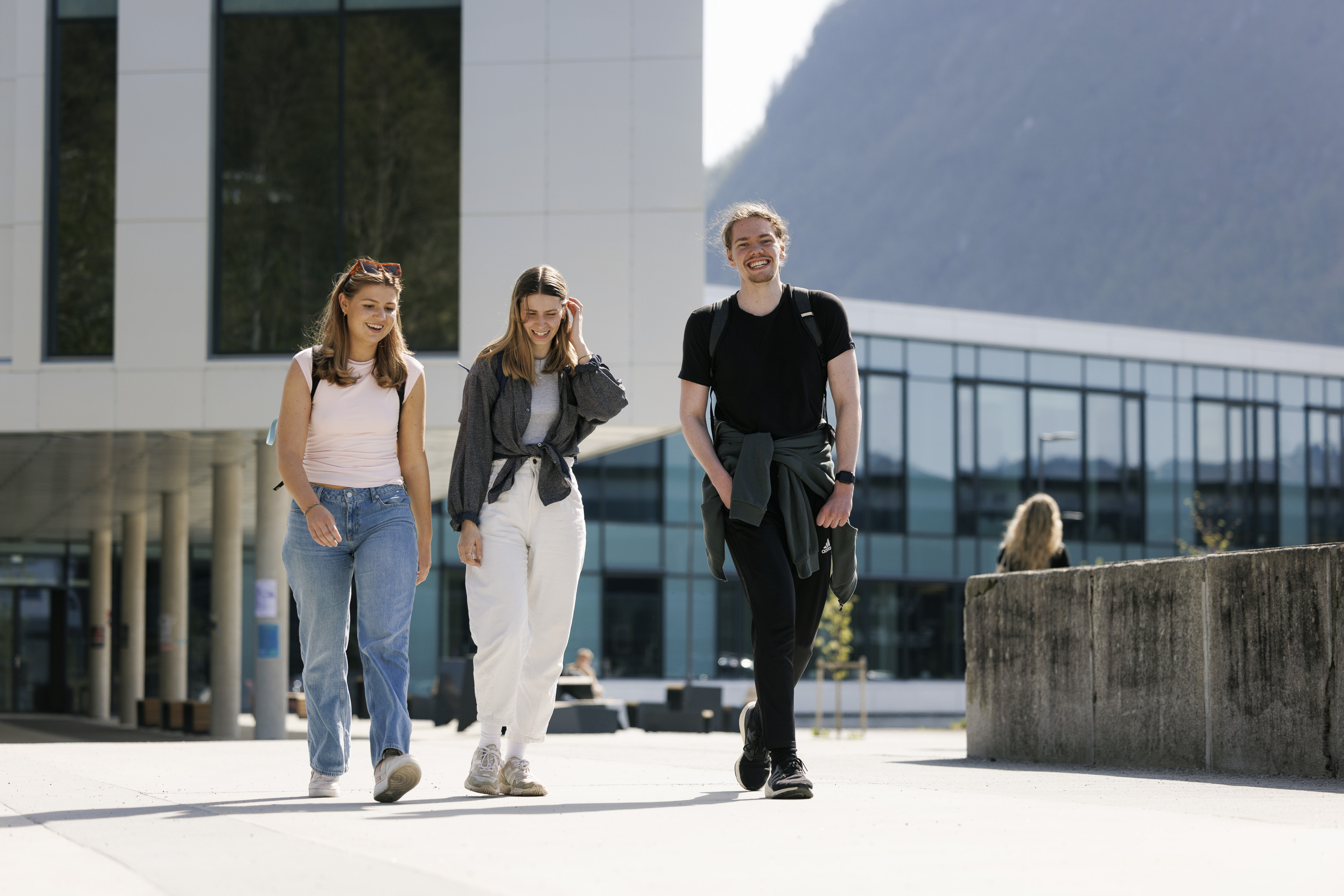 Tre studenter som g&aring;r fremfor mediebygget