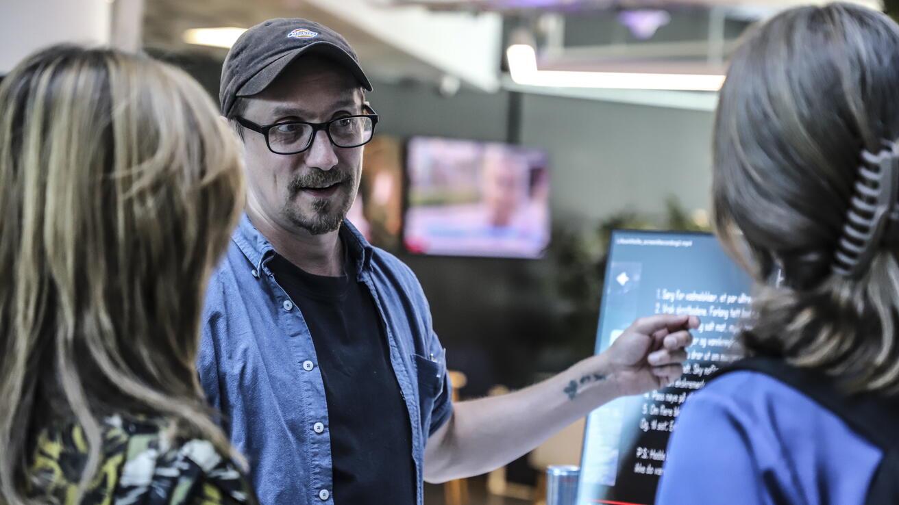 Person showing his project to two women